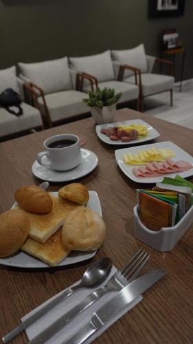 a table with plates of bread and a cup of coffee at Equo Hotel Boutique in Lima