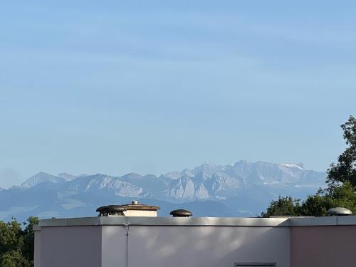 a white building with mountains in the background at Moderne & helle Wohnung mit Netflix & Bergsicht in Wetzikon