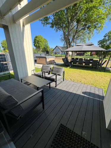 a wooden deck with benches and an umbrella at Mazurskie Niebo Apartament 2 in Gołdap