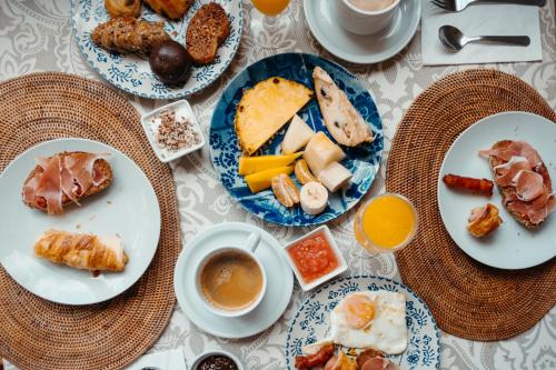 a table with plates of food and cups of coffee at Cortijo Los Malenos in Agua Amarga