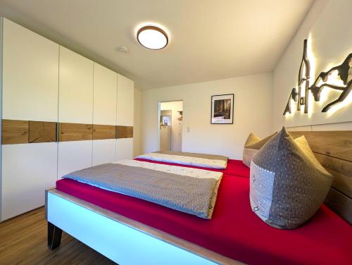 a bedroom with a large bed with a red blanket at Ferienwohnung Alpenglut in Nesselwang