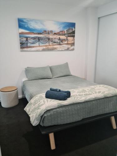 a bedroom with a bed with a painting on the wall at 3 Bedroom Sub Penthouse Apartment in the heart of Newcastle in Wickham