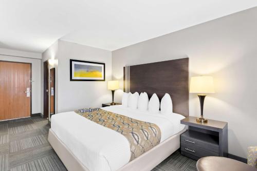 a hotel room with a large bed and a chair at Best Western Naperville Inn in Naperville