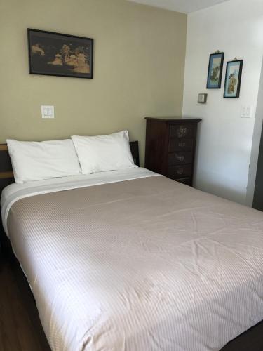 a bedroom with a large white bed and a dresser at Slumber Lodge in Hope