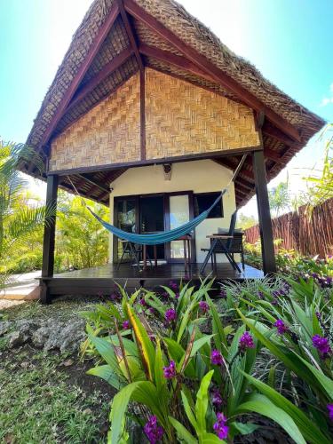 a resort with a hammock in front of it at Turtle Bay Beach House in Saraotou