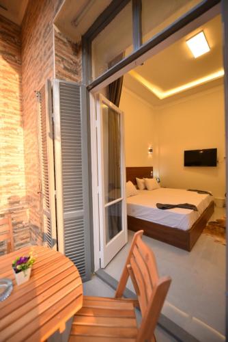 a bedroom with two beds and a balcony with a table at family suites cairo downtown in Cairo