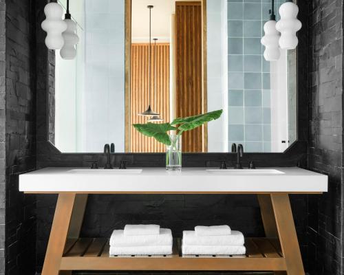 a bathroom with a white sink and a mirror at Kimpton - Grand Roatan Resort and Spa in West Bay