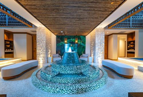 a large blue fountain in a room with white chairs at Kimpton - Grand Roatan Resort and Spa in West Bay