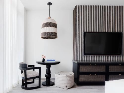 a living room with a tv and a table at Kimpton - Grand Roatan Resort and Spa in West Bay