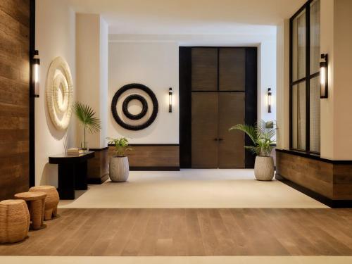a lobby of a hotel with a door and plants at Kimpton - Grand Roatan Resort and Spa in West Bay