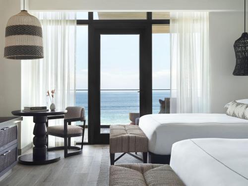 a bedroom with a bed and a view of the ocean at Kimpton - Grand Roatan Resort and Spa in West Bay