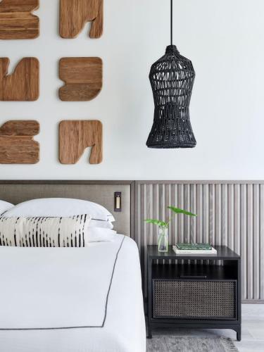 a bedroom with a white bed and a black nightstand at Kimpton - Grand Roatan Resort and Spa in West Bay