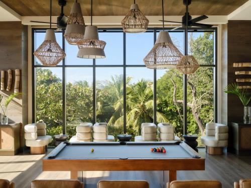 a pool table in a room with a large window at Kimpton - Grand Roatan Resort and Spa in West Bay