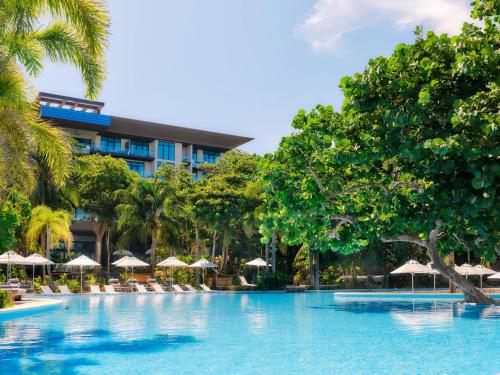 a pool at a resort with chairs and umbrellas at Kimpton - Grand Roatan Resort and Spa in West Bay
