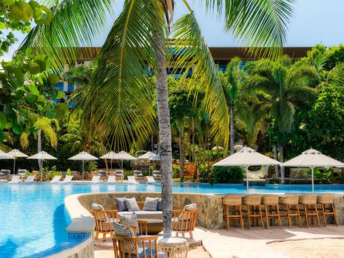 a resort with a pool with chairs and umbrellas at Kimpton - Grand Roatan Resort and Spa in West Bay