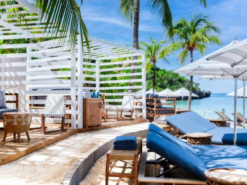 a resort patio with chairs and tables and the ocean at Kimpton - Grand Roatan Resort and Spa in West Bay