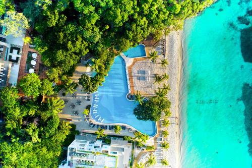 an aerial view of a resort with a pool and the ocean at Kimpton - Grand Roatan Resort and Spa in West Bay