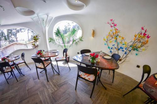a dining room with two tables and chairs and two windows at Wifala Harmony Hotel in Urubamba