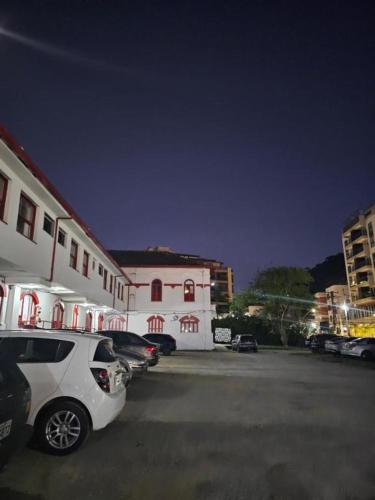 a white car parked in a parking lot next to a building at Varzea Palace Hotel in Teresópolis