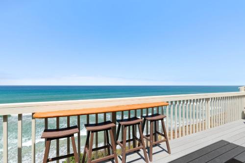 a pair of stools sitting on a balcony overlooking the ocean at Picturesque Perfection in Leucadia Encinitas in Encinitas