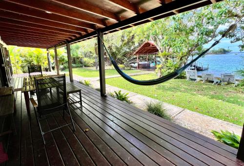 a porch with a hammock and a view of the water at Turtle Bay Beach House in Saraotou