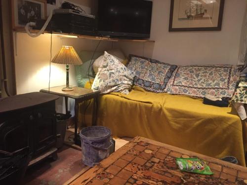 a bedroom with a bed and a table with a lamp at Airebroc Byre in Uig
