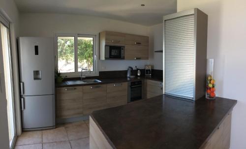 une cuisine avec un réfrigérateur blanc et une fenêtre dans l'établissement U capannellu, à Calcatoggio