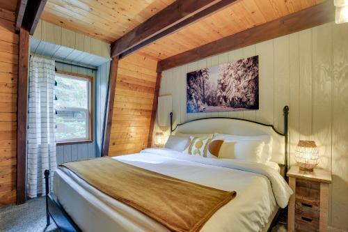 a bedroom with a large bed in a wooden room at Rhododendron Family Cabin Hot Tub and Deck! in Rhododendron