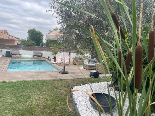 une cour arrière avec une piscine et une terrasse en bois dans l'établissement Studio Cosy, à Castanet-Tolosan