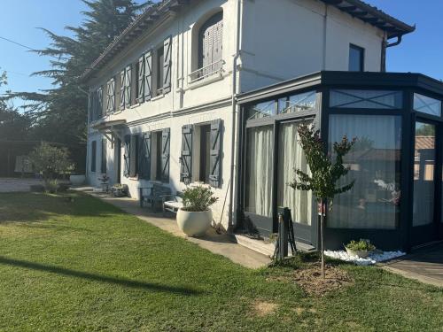une maison blanche avec un arbre devant dans l'établissement Studio Cosy, à Castanet-Tolosan