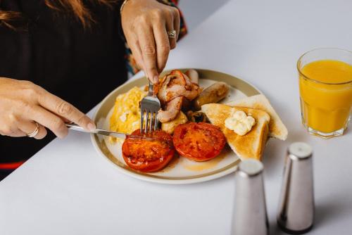 a person is eating a plate of breakfast food at Kennedy Park Resort Napier in Napier