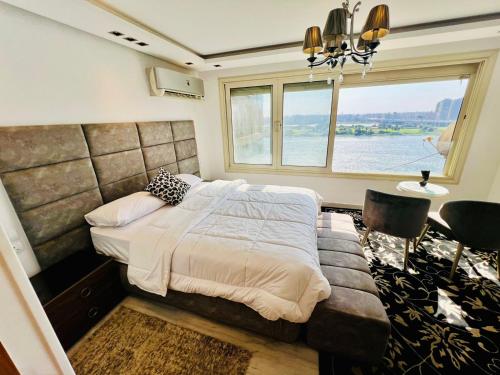 a bedroom with a large bed and a window at شقة فندقية على النيل مباشر بالمعادى بجوار فندق الهيلتون مباشره in Cairo