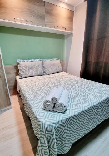 a bedroom with a bed with towels on it at Casa Cond Ocean House Camboinhas Pé na Areia 4qts in Niterói
