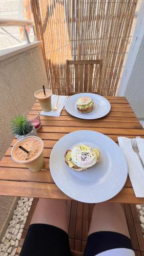 a person sitting at a table with plates of food at D'azur Home in Vlorë