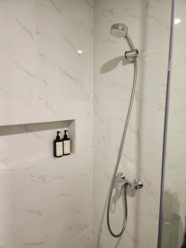 een douche in een badkamer met een glazen deur bij de' Asasta Apartment Benoa E216 in Nusa Dua