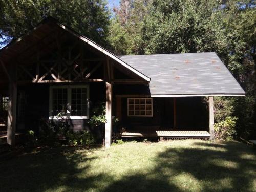 a small house with a gambrel roof in a yard at House on Calafquen lake in Panguipulli