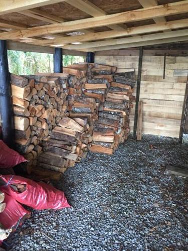 a pile of logs sitting inside of a building at House on Calafquen lake in Panguipulli