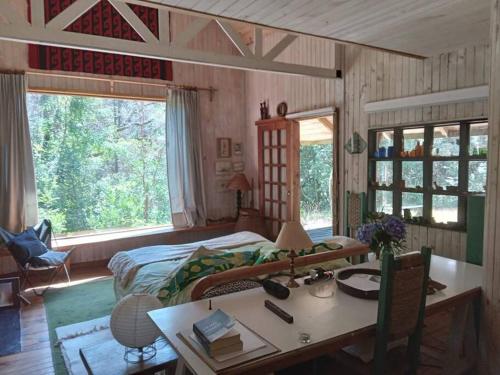 a bedroom with a desk and a bed and a table at House on Calafquen lake in Panguipulli