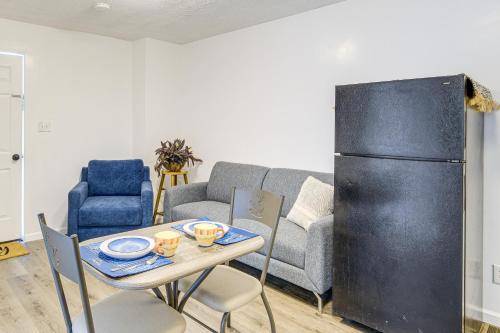 a living room with a table and a refrigerator at Walkable Barberton Apartment 9 Mi to Akron! in Barberton