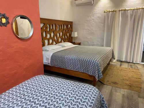 a small room with two beds and a mirror at Suitehome in Bahía de la Academia