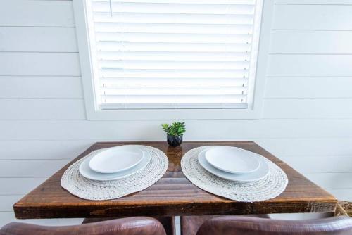 a wooden table with two white plates on it at The Stardust Stunning Container Home in Alpine