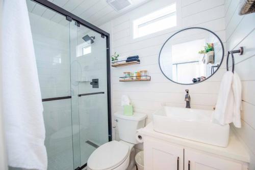 a bathroom with a toilet and a sink and a shower at The Stardust Stunning Container Home in Alpine
