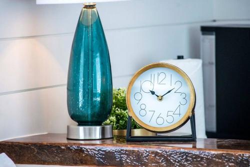 a green vase and a clock on a table at The Stardust Stunning Container Home in Alpine