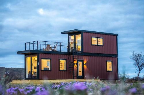 a house with a balcony on top of it at The Stardust Stunning Container Home in Alpine