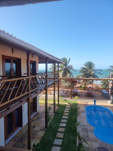 a view of a resort with a swimming pool and the ocean at Pousada Quinta do Mar in Icapuí