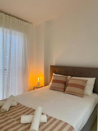 a bedroom with a large white bed with a window at Casa da Aldeia in Bensafrim