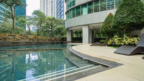a swimming pool in front of a building at Premium 1BR unit at The Avant in Manila