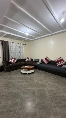 Una sala de estar con sofás y una mesa de café. en Duplex a sidi Bouzid pour famille - Luxury Mini Villa with Swimming Pool, en Sidi Bouzid