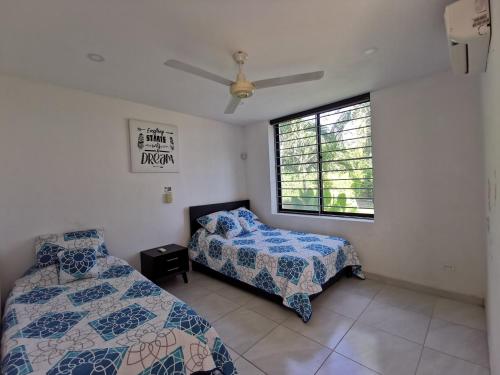 a bedroom with two beds and a window at Casa condominio santa ana in Flandes