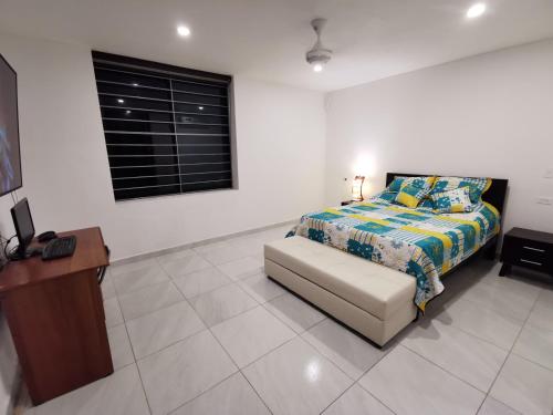 a bedroom with a bed and a table and a desk at Casa condominio santa ana in Flandes